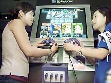 Nintendo attendants demonstrate the new Nintendo GameCube video game console at an unveiling in Tokyo on Thursday.