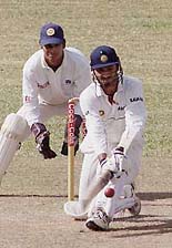 Harbhajan Singh (R) hits a four as wicketkeeper Kumar Sangakkara looks on during the second day of the second Test between India and Sri Lanka at Asgiriya International Cricket Stadium in Kandy, Sri Lanka on Thursday.