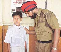 A police constable listens to Santosh Pujari at the Ludhiana railway station on Saturday. 