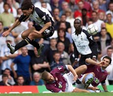 Manchester United's striker Ruud Van Nistelrooy (L) leaps over the fallen Olof Mellberg (2L) and Alpay Ozalan (R) of Aston Villa as team mate Andy Cole watches during the English premier league match against Aston Villa at Villa Park on Sunday. 