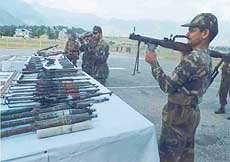 An armyman displaying rocket launcher, other arms and ammunition captured from militants in Kishtwar tehsil of Doda district 220 km from Jammu on Wednesday.