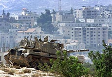 An Israeli tank takes position after it enters the West Bank town of Beit Jala