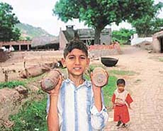 A 10-year-old boy, Rajkumar, carrying two bombshells on his shoulders 