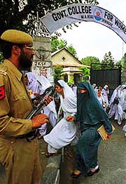 A policeman keeping vigil at the exit gate of Government College for Women in Srinagar .