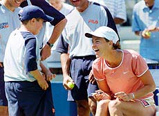 Lindsay Davenport laughs with a ball boy 