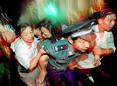 A Chinese policeman rescues a woman during a fire.