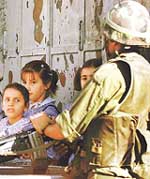 Israeli soldiers stop Palestinian students from going to their school.