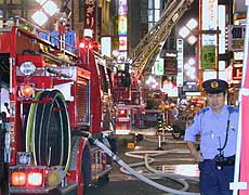 A policeman stands guard beside fire engines after an explosion and fire ripped through a four-storey building.