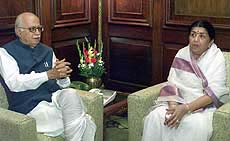 Home Minister L. K. Advani (L) talks with Lata Mangeshkar.