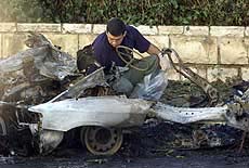An Israeli policeman examines the wreck of a car bomb