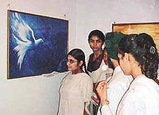 Students admire the painting Peace that was declared the best in a painting competition.