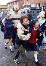 Roman Catholic girls and their parents make their way through a Protestant area to the Holy Cross Roman Catholic School in north Belfast on Wednesday. 