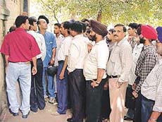 People wait outside a court to get their challans cleared.