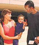 American track star Michael Johnson (right) pinches the cheek of his young son.
