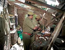CRPF personnel inspecting the damage caused by a suicide bomber 