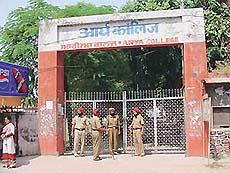 Security personnel stand outside Arya College.