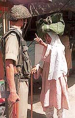 An old Kashmiri woman argue with a paramilitary soldier during the cordon and search operation in Srinagar on Sunday.