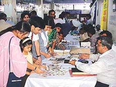 The prospective buyers examinig stamps and coins at the Stamps and coin Bazaar organised today in the main post office.