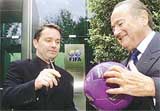 Yahoo! President Jeff Mallett (L) and FIFA President Joseph Blatter put their signatures on a soccer ball in Zurich on Tuesday.