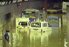 Tokyo municipal office workers inspect 27 vehicles stuck in a tunnel inundated in flood water near Tokyo's Haneda airport on Tuesday.