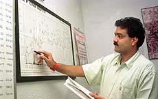 Rajesh Bajaj, an Indian stockbroker, checks an index chart at his office in Calcutta on Thursday.