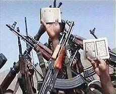 Recruits of Saudi-born militant Osama bin Laden wave their guns and display Korans.