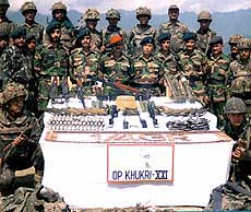 A security jawan with a heavy weapon keeping watch on the vehicles heading for Srinagar airport .