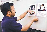 Rao Chalasani adds a poster for his missing sister Swarna on a wall outside Bellevue hospital on Thursday. 