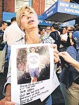 Trudy Calandrillo holds a photo of her brother, Joseph, who has been missing since Tuesday's World Trade Center attack, at the 69th Regiment Armory in New York on Thursday. 
