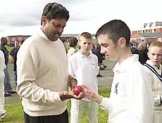 World Sports Academy member Kapil Dev explaining bowling grips to Derry schoolboy David Thompson in north of Ireland as children from both sides of the border came together to participate in sporting activities. 