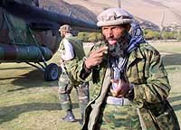An Afghan Northern Alliance soldier passes by a helicopter in the village of Malaspa, Panjshir Valley, on Saturday.