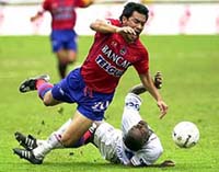 Carlos Ruiz (left) of Guatemala's Municipal, is tackled by Elvis Turcios (right) of Olympia of Honduras in the Central American Club Championship in San Jose