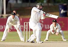 South African opening batsman Gary Kirsten drives to cover watched by Zimbabwe's Alistair Campbell (L) and Paul Strang on Sunday. 
