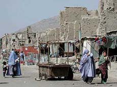 Afghans walk past a ruined site in Kabul on Wednesday.