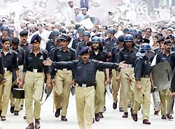 Pakistani riot police lead marching anti-U.S. demonstrators during a protest in Peshawar on Thursday. 