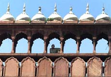 A Muslim man sits in the upper gallery of Jama Masjid.
