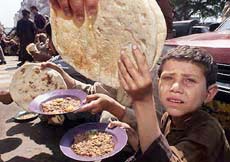 An Afghan child who earns a meager living collecting garbage receives free food outside a restaurant in Karachi on Tuesday. 
