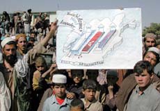 Afghan demonstrators hold a map of Afghanistan depicting British and Russian graves, and the phrase "You're welcome, next invader" by an American grave in Kabul on Wednesday.