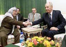 Israeli Foreign Minister Shimon Peres and Palestinian President Yasser Arafat shake hands after talks in Rafah on Wednesday. 