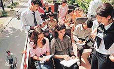 Tourist participates in "Tourism Slogan Writing Competetion" on Hop On -Hop Off tourist coach to mark the world Tourism day in Chandigarh on Thursday.