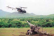 A Cheetah helicopter flys over a Bofors gun at a fire power demonstration in Devlali on Wednesday.