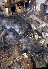Kashmiri fire fighters work amid the rubble of a hotel gutted by fire