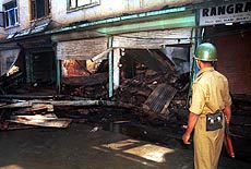 A Paramilitary soldier walks near the debris of a hotel