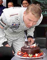 McLaren team driver Mika Hakkinen of Finland blows out candles at the Indianapolis Motor Speedway for his 33rd birthday on Friday. 