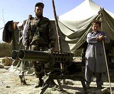 An Afghan Northern Alliance soldier stands with a refugee boy behind a recoilless gun near the Afghan-Tijak border, some 30 km from the small Afghan town of Imam Saheeb, on Friday.