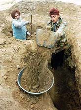 Lakha Singh, a retired Army officer, and his son dig a trench outside their house in Ratangarh village, 2 km from the Punjab border, on Wednesday. 