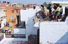 Municipal Corporation staff remove an illegal structure in Sector 47, Chandigarh, on Friday. 