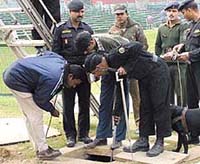 Security personnel with sniffer dogs check a manhole for explosives at Rajpath.
