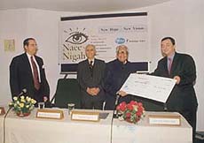 Mr Holine Sidi presents a cheque of Rs 60 lakh to R. Venkataraman, the patron of HelpAge India.