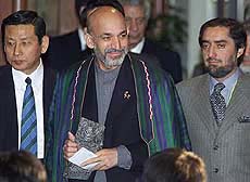 Afghan interim leader Hamid Karzai (C), accompanied by Afghan Foreign Minister Abdullah Abdullah